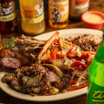 Escovitch fish with peppers and onions over rice and peas, with a bottle of Ting.