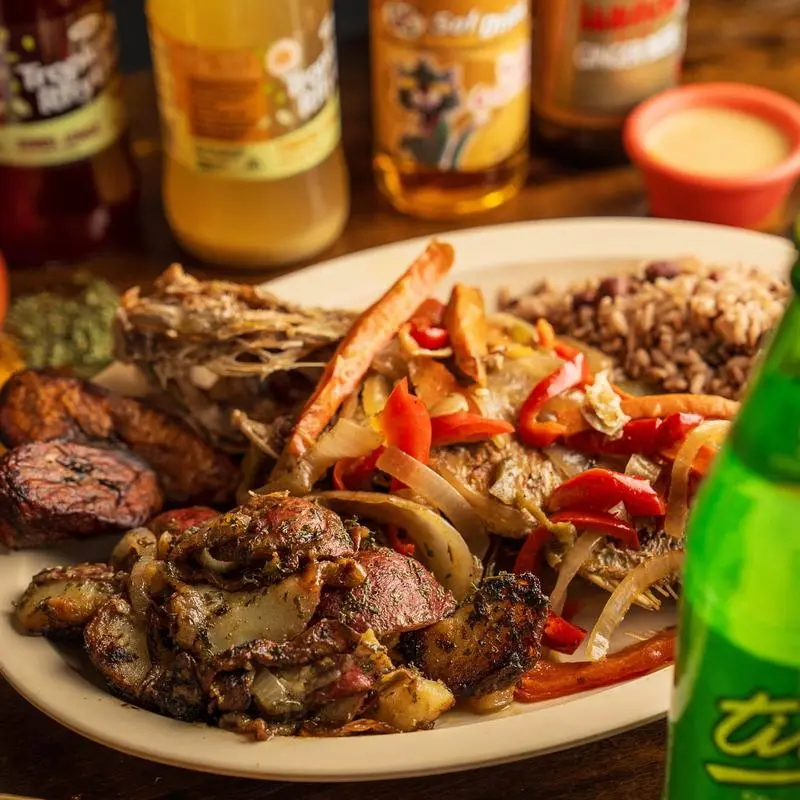 Escovitch fish with peppers and onions over rice and peas, with a bottle of Ting.