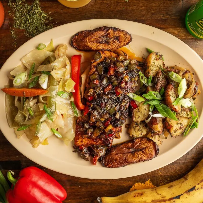 Jerk chicken with cabbage, skillet potatoes and fried plantains.