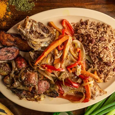 Escovitch fish with onions and peppers over rice and peas, with fried plantains.