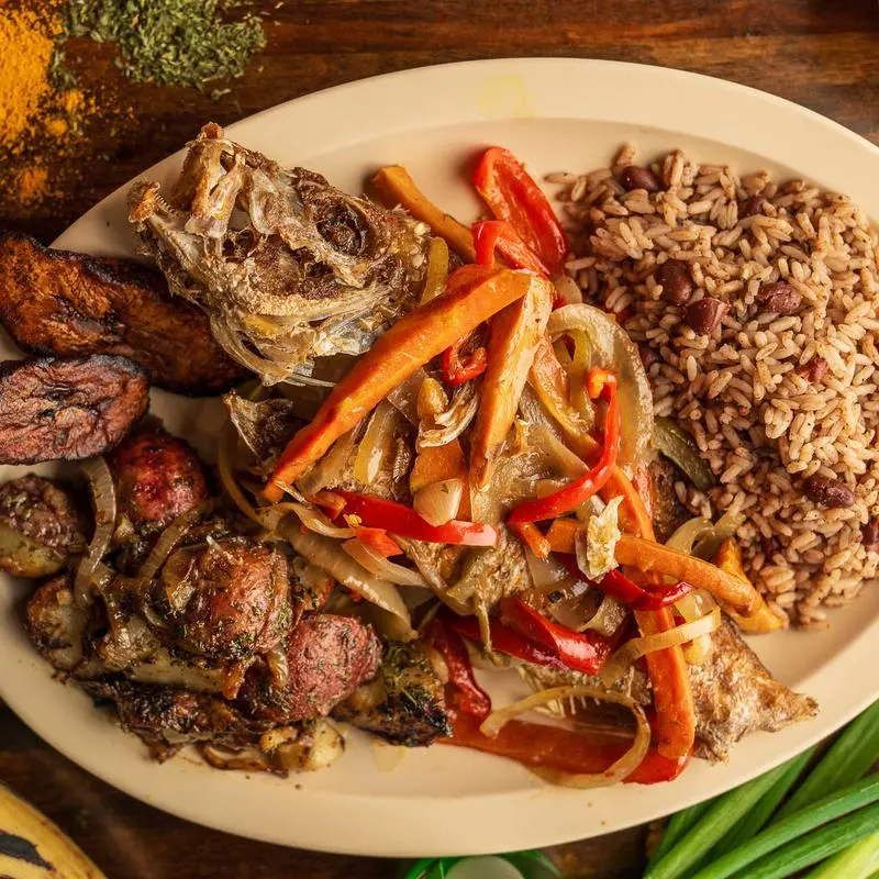 Escovitch fish with onions and peppers over rice and peas, with fried plantains.