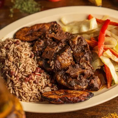Jerk chicken with rice and peas, cabbage and fried plantains.