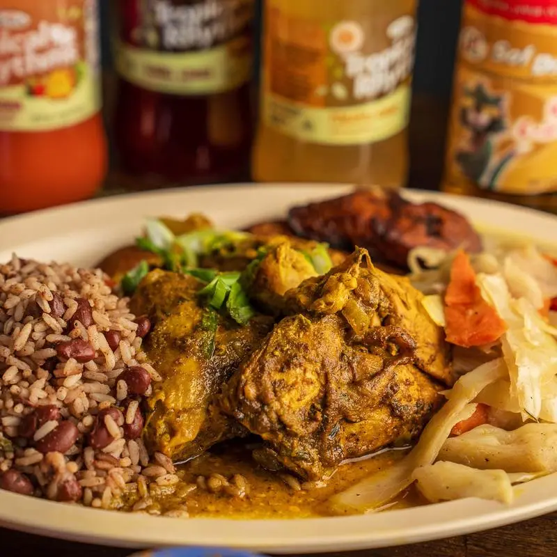 Curry chicken with rice and peas and pasta, topped with scallions.